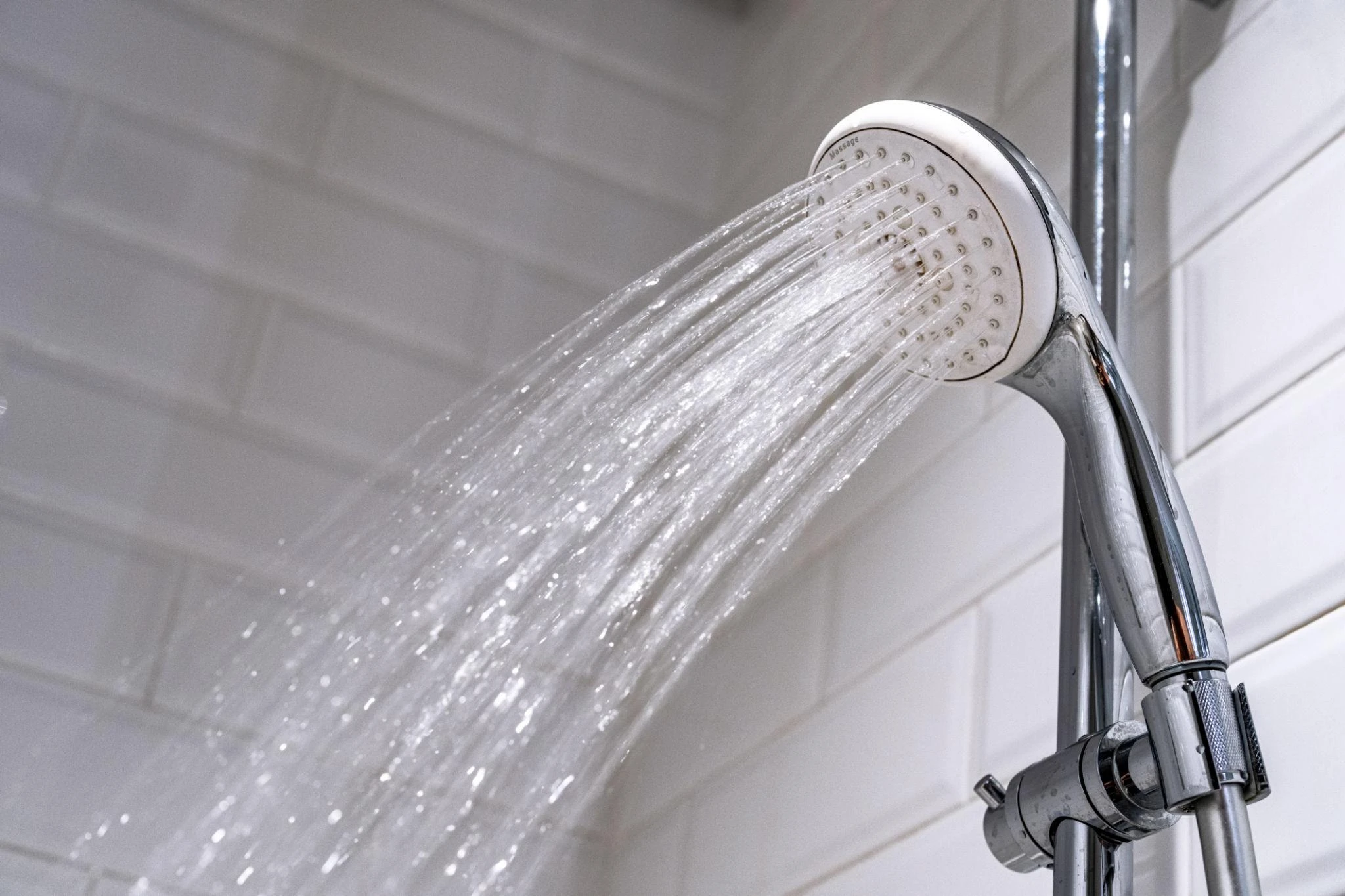 Close-up of water flowing from a shower head in a modern bathroom